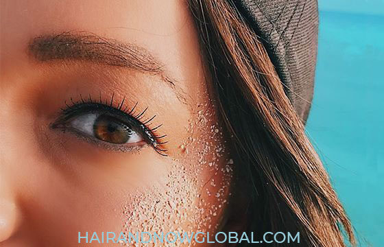 Eyelash solutions- Female with sand on her face wearing false eyelashes at the beach