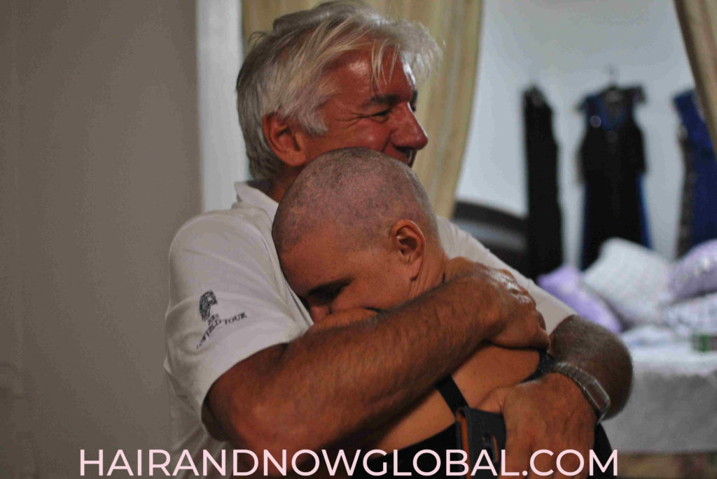 Female breast cancer victim hugging her father after losing her hair for the first time