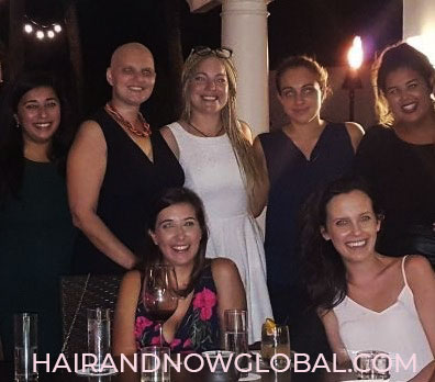 Group-of-females-standing-around-dinner-table-with-breast-cancer-survivor