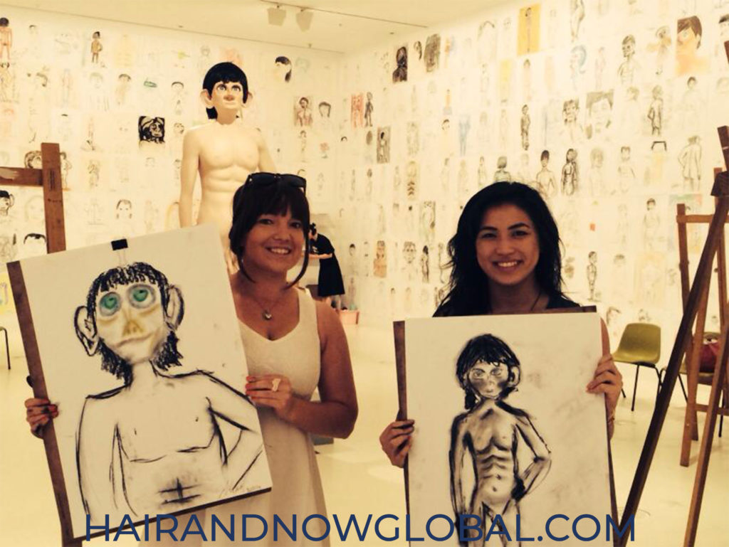 two females at Melbourne art gallery exhibition, female on left wearing capless wig with bangs