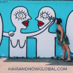 SaraErenthalArt- blue mural-in El-Salvador of two bald surfers showing each other affection