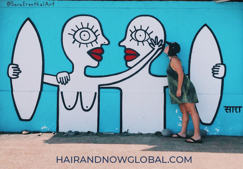 SaraErenthalArt- blue mural-in El-Salvador of two bald surfers showing each other affection