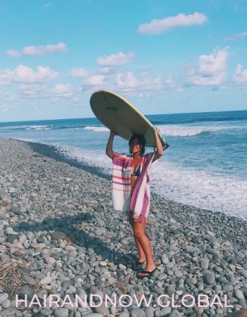 Female-wearing-wig-with-surf-board-in-El-Salvador
