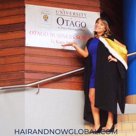 female in graduation gown and cap, wearing capless wig